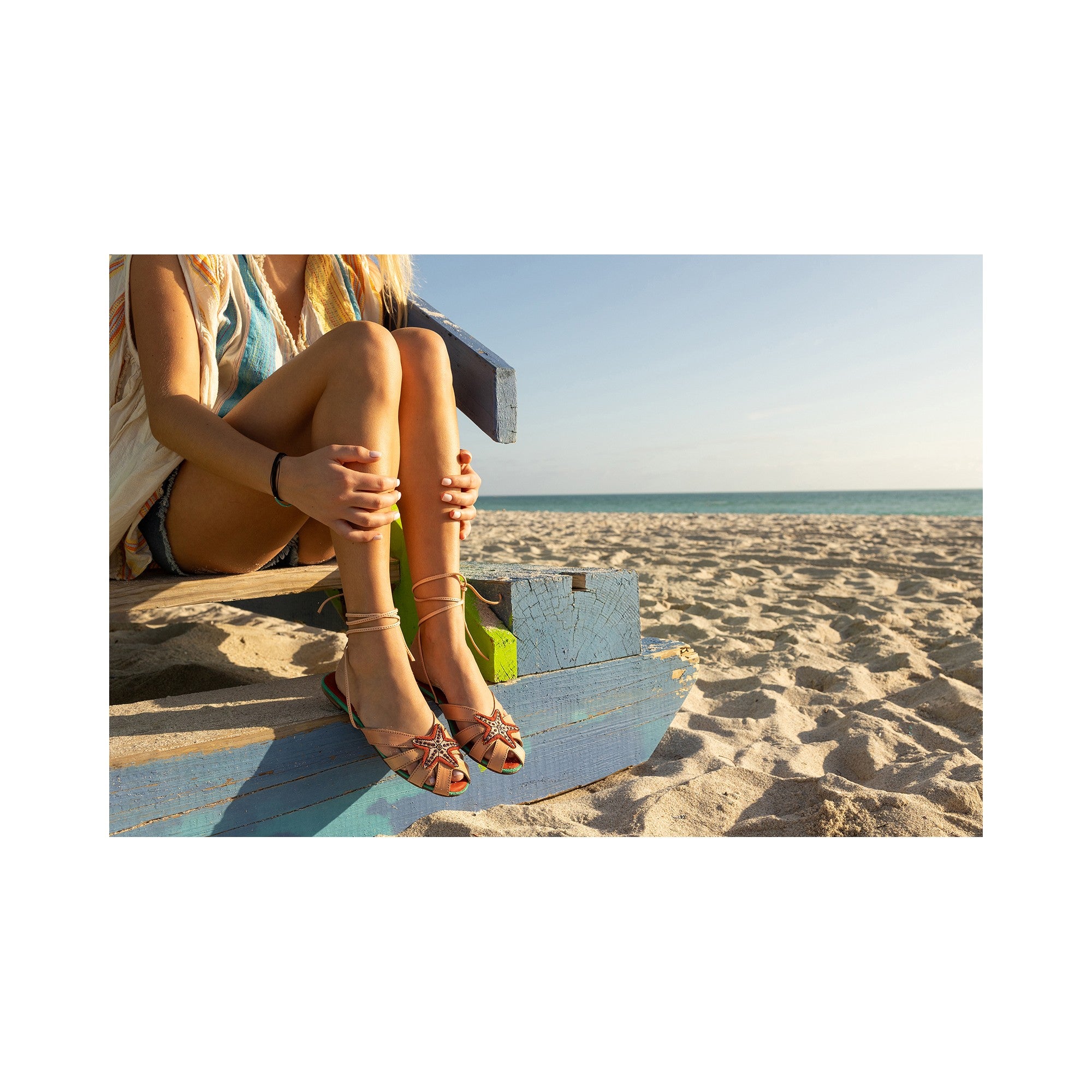 Meher Kakalia EZILI SLIDE sandals on a beach, perfect for summer with their breathable and stylish design.