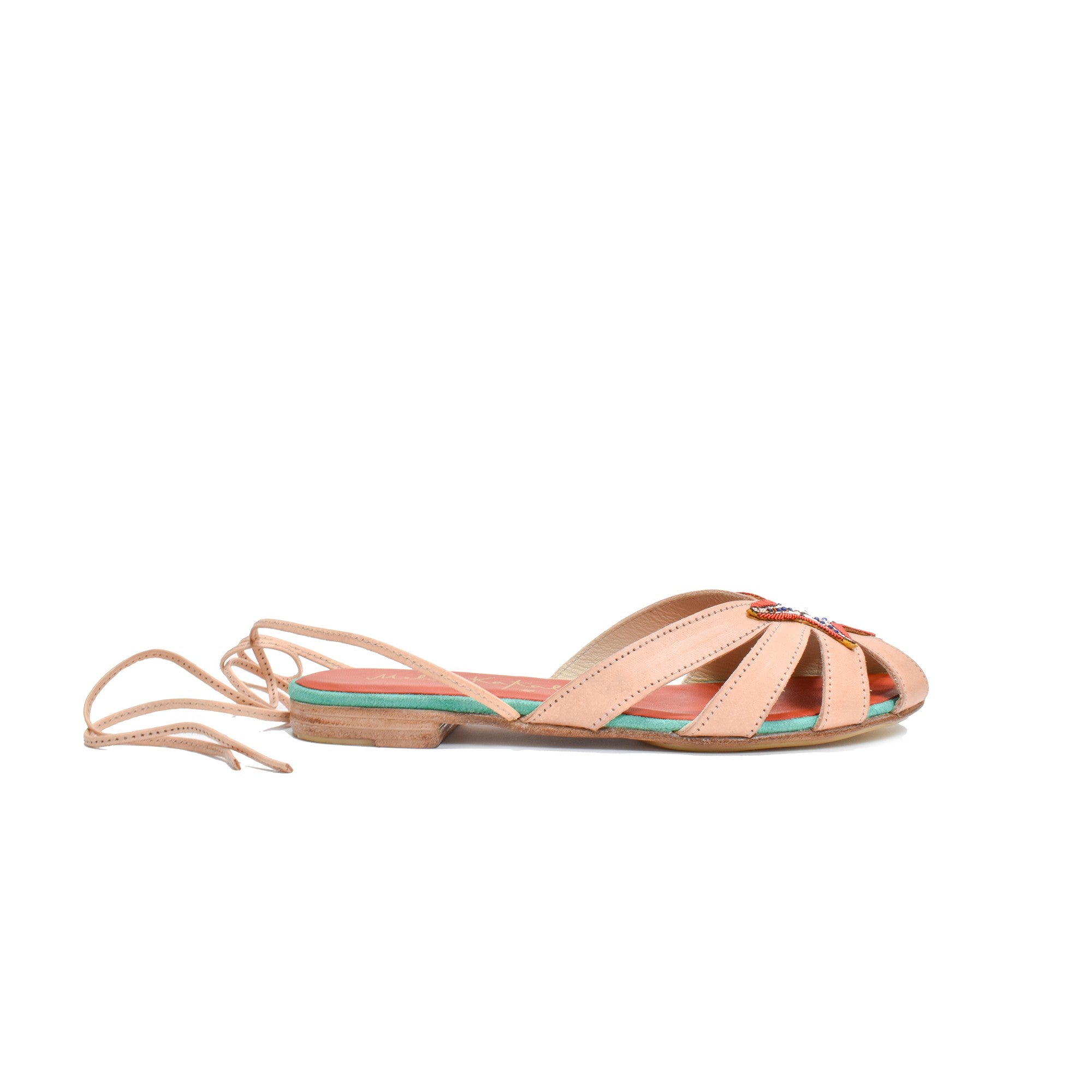 Side view of Meher Kakalia sandals, showcasing soft leather straps, embroidered starfish detail, and a comfortable flat sole.