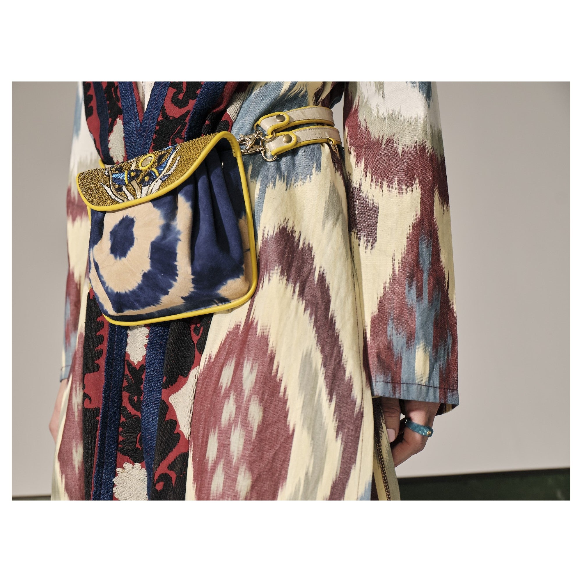 Model wearing the mini suede bag as a belt bag, showcasing its tie-dye pattern and intricate embroidery.