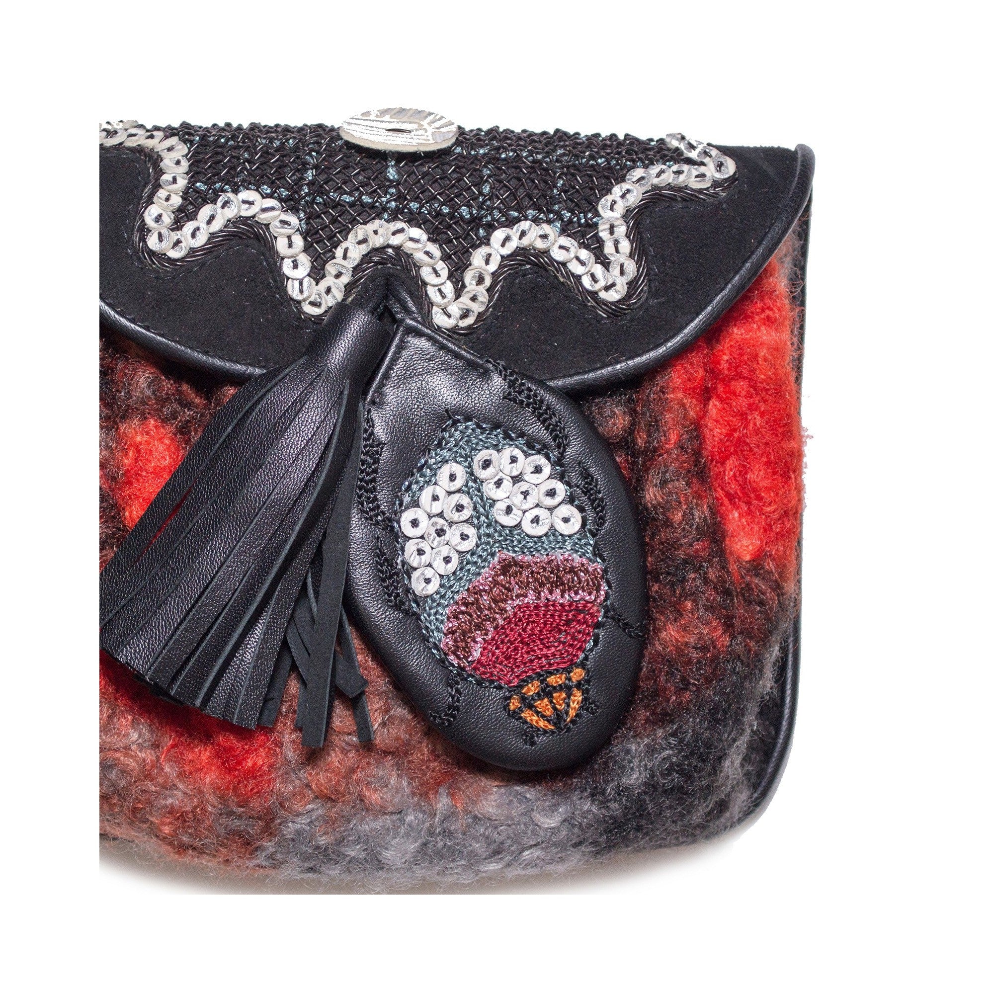Close-up of the Mini Bag by Meher Kakalia in black and red, featuring a hand-embroidered leather motif and leather tassel