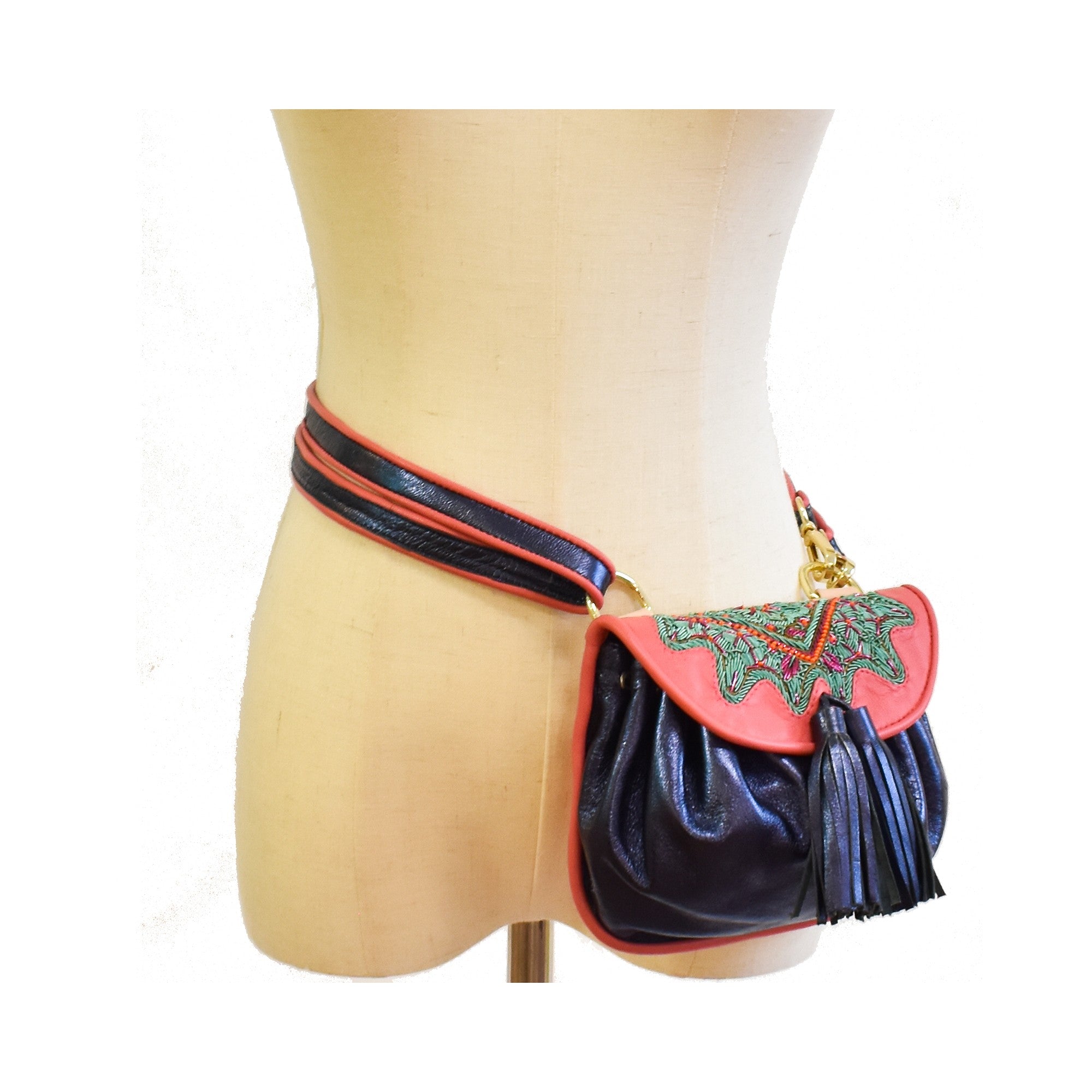 Mini leather belt bag in deep blue with pink embroidered flap and tassels.