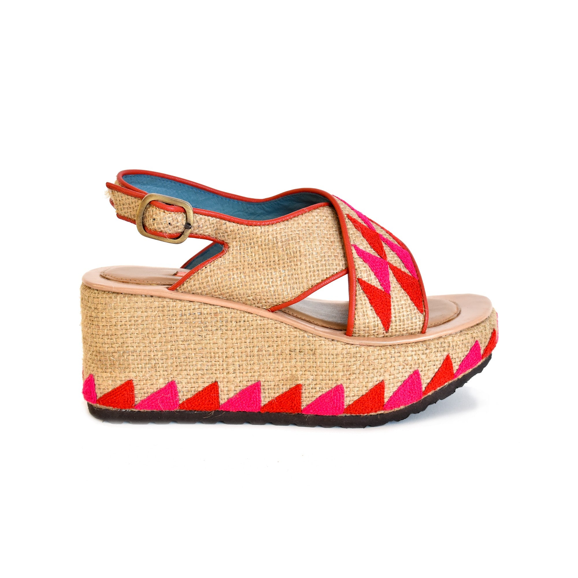 Woven jute wedge sandal with coral and pink geometric embroidery and ankle strap.