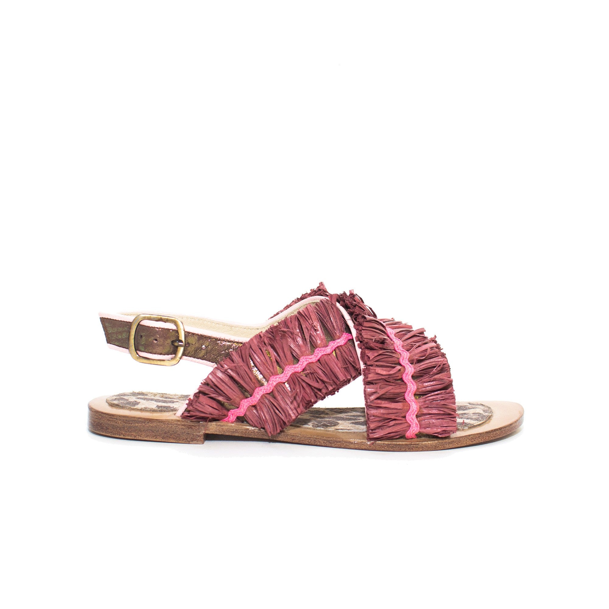 Side view of eco-friendly raffia sandal with gold buckle and crossover straps.